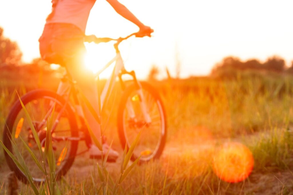 Fahrradfahrerin im warmen Licht eines spätsommerlichen Tages